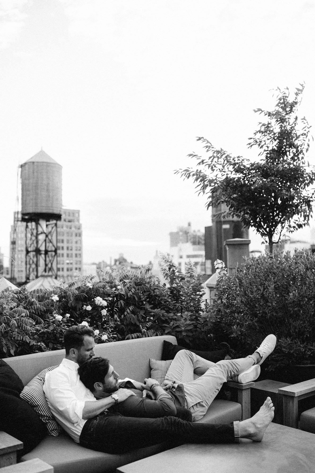 Couple cuddling on couch on rooftop in Manhattan