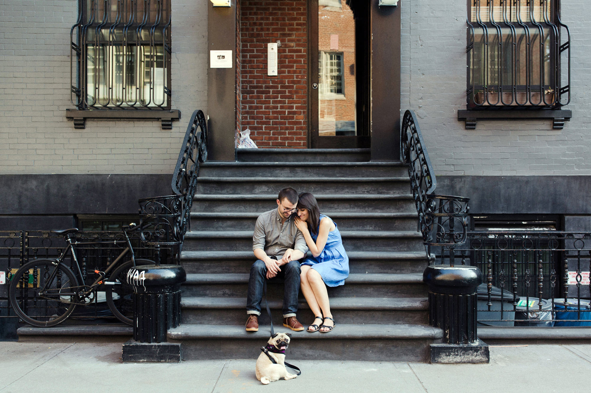 Couple sitting on New York stoop with a dog