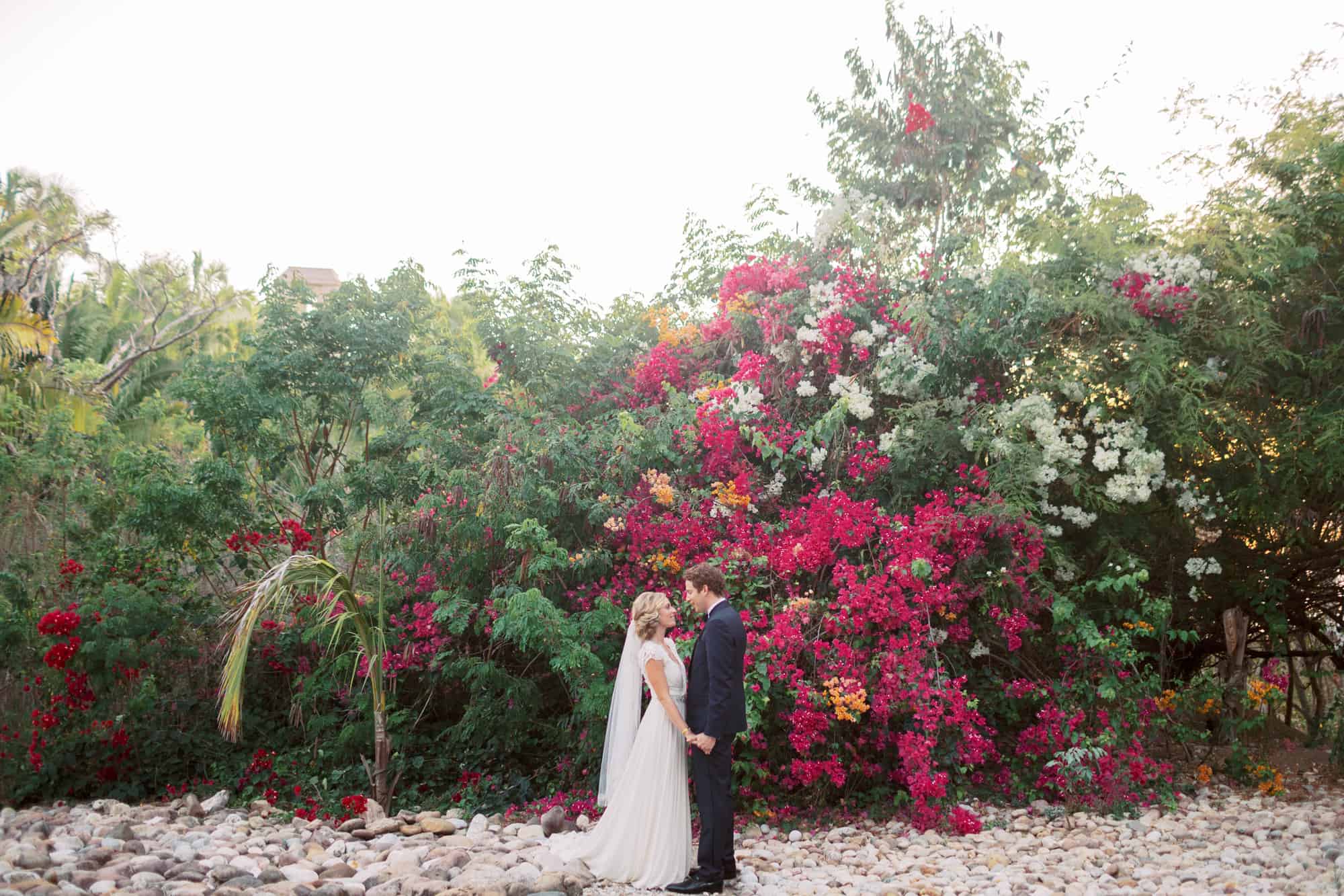 Wedding portrait in front of bougainvillea in Mexico
